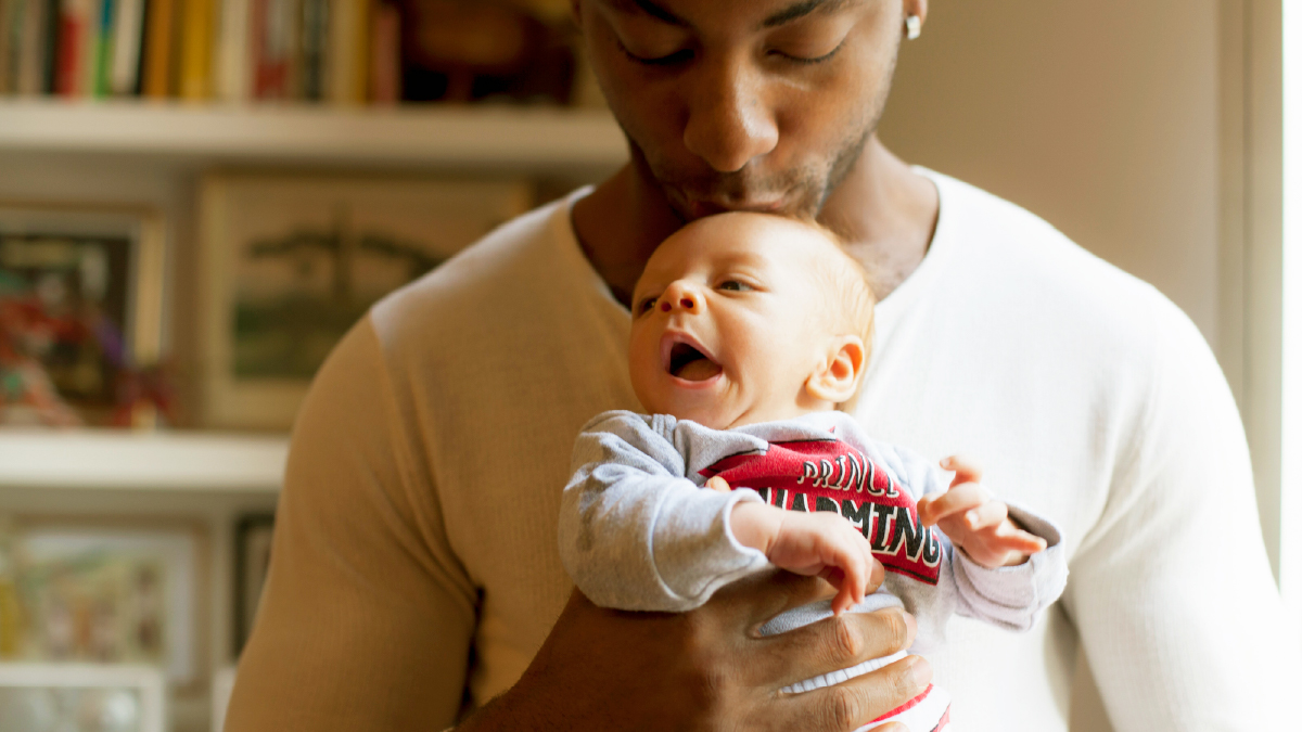 Un père fait un bisous à son nouveau né