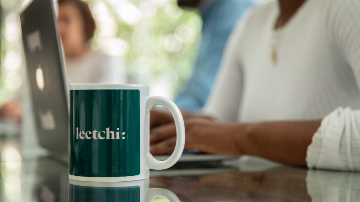 Une tasse Leetchi à côté d'un ordinateur 